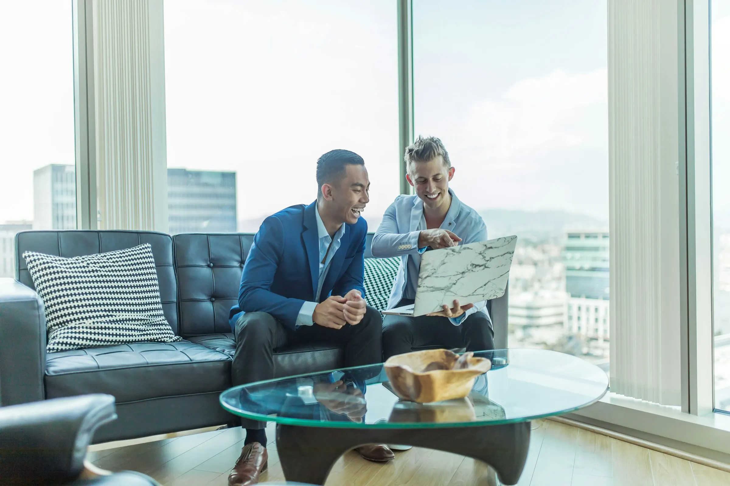 Real estate professionals meeting with clients across a table in a bright modern office to review a home purchase