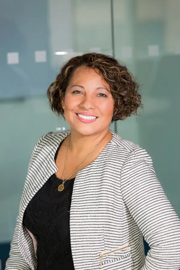 Professional headshot of a woman real estate agent in business attire against a neutral background
