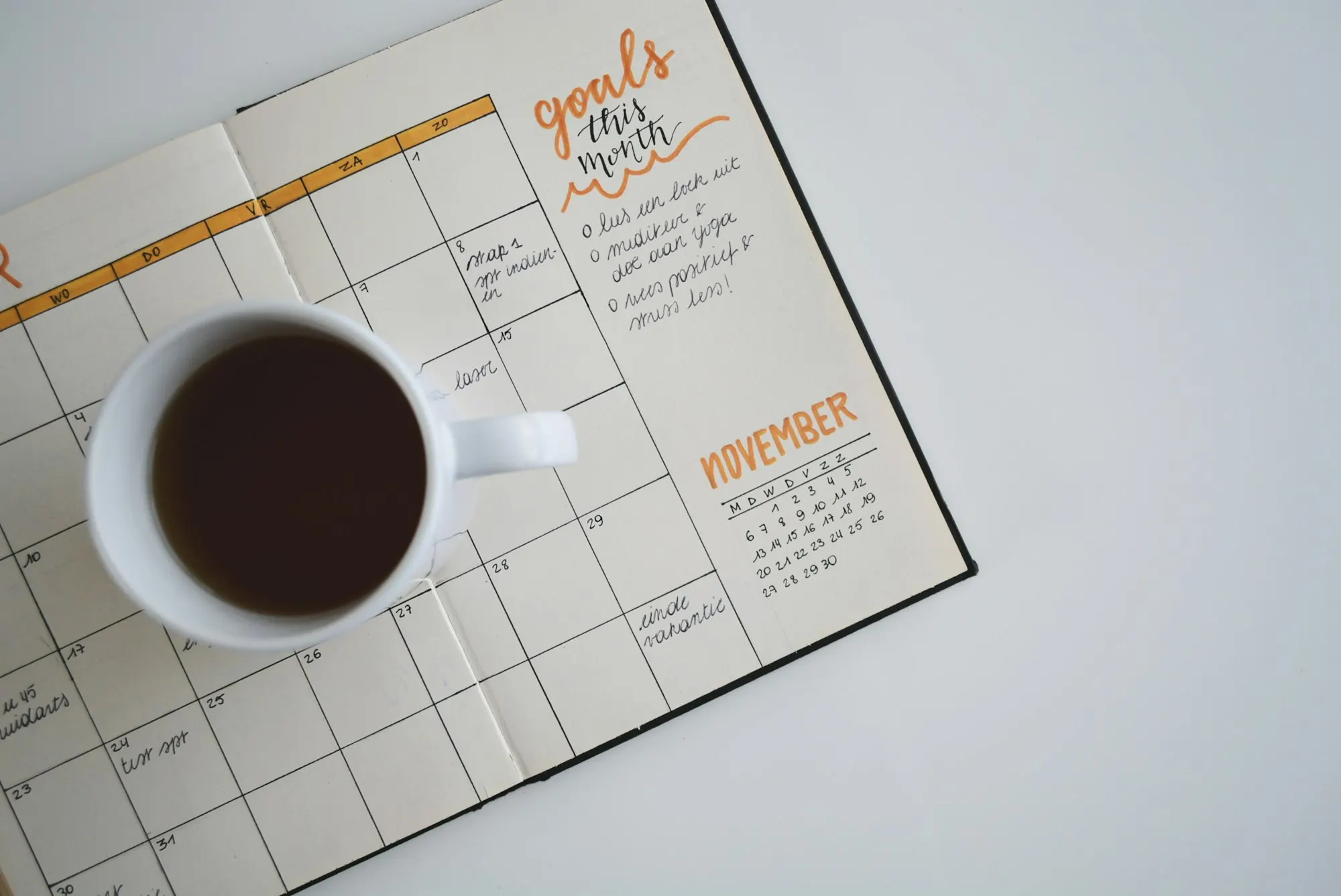 Monthly wall calendar beside a cup of coffee, marking deadlines for a 1031 exchange